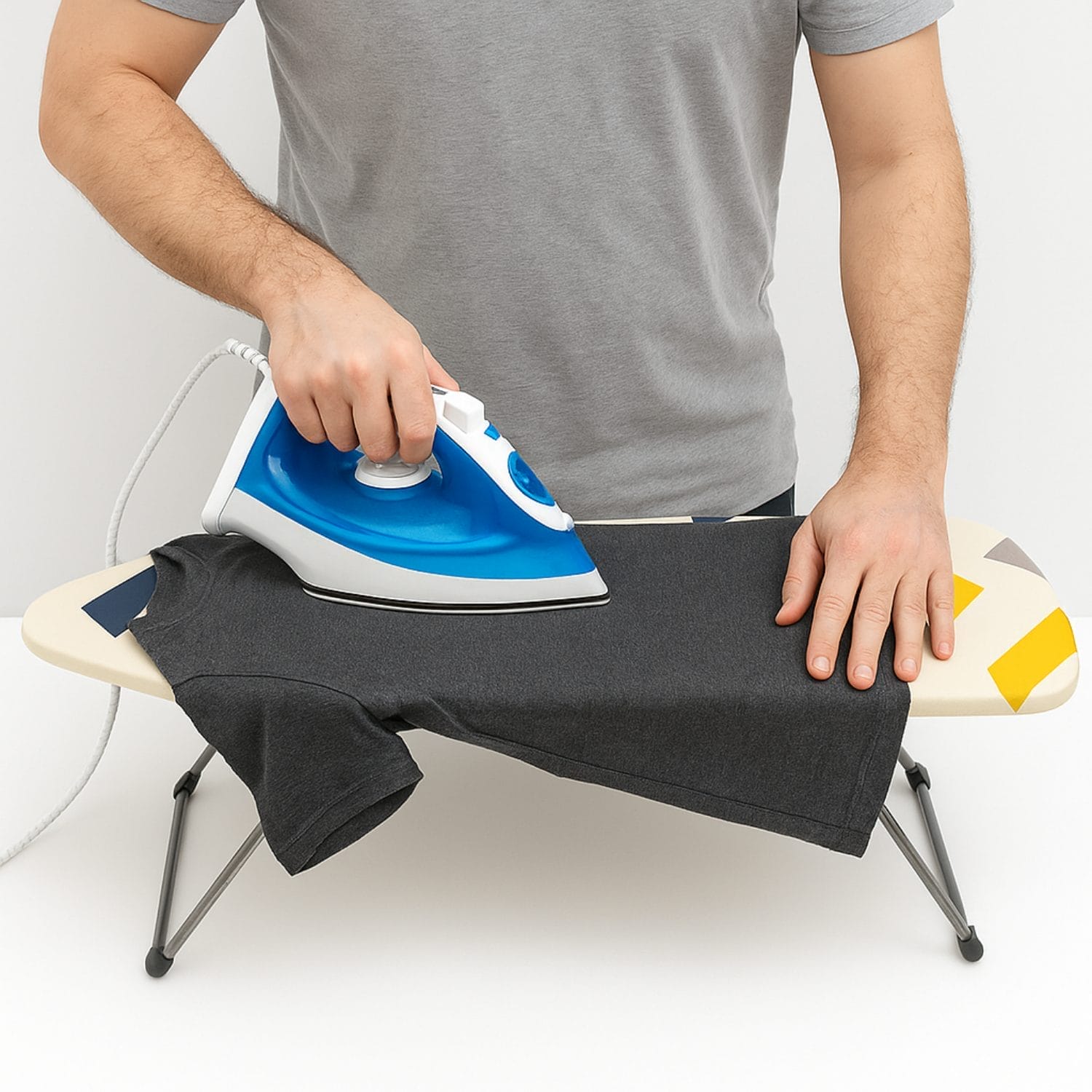 Persona che stira una maglietta su mini asse da stiro da tavolo Paluplus