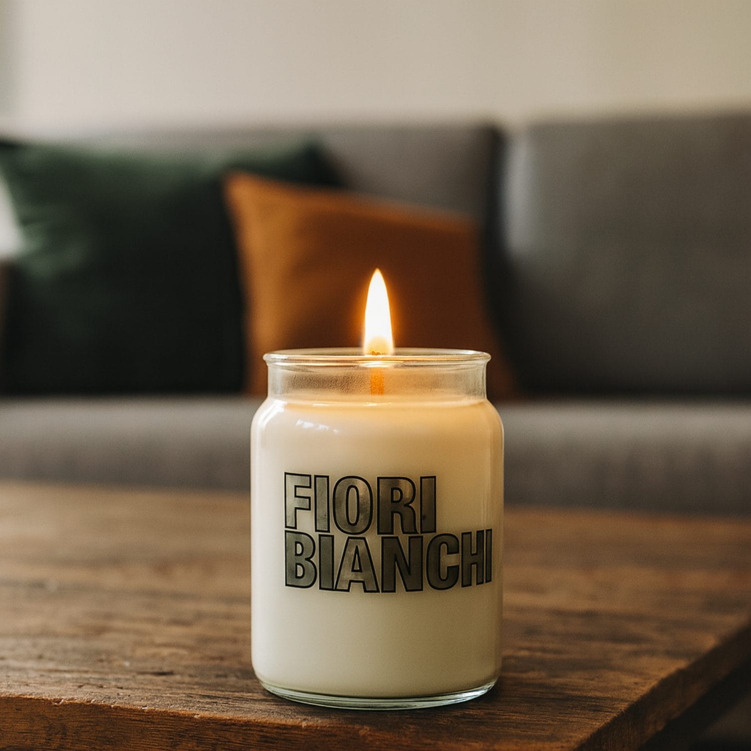 Candela in giara Fiori Bianchi accesa appoggiata su tavolino in salotto moderno