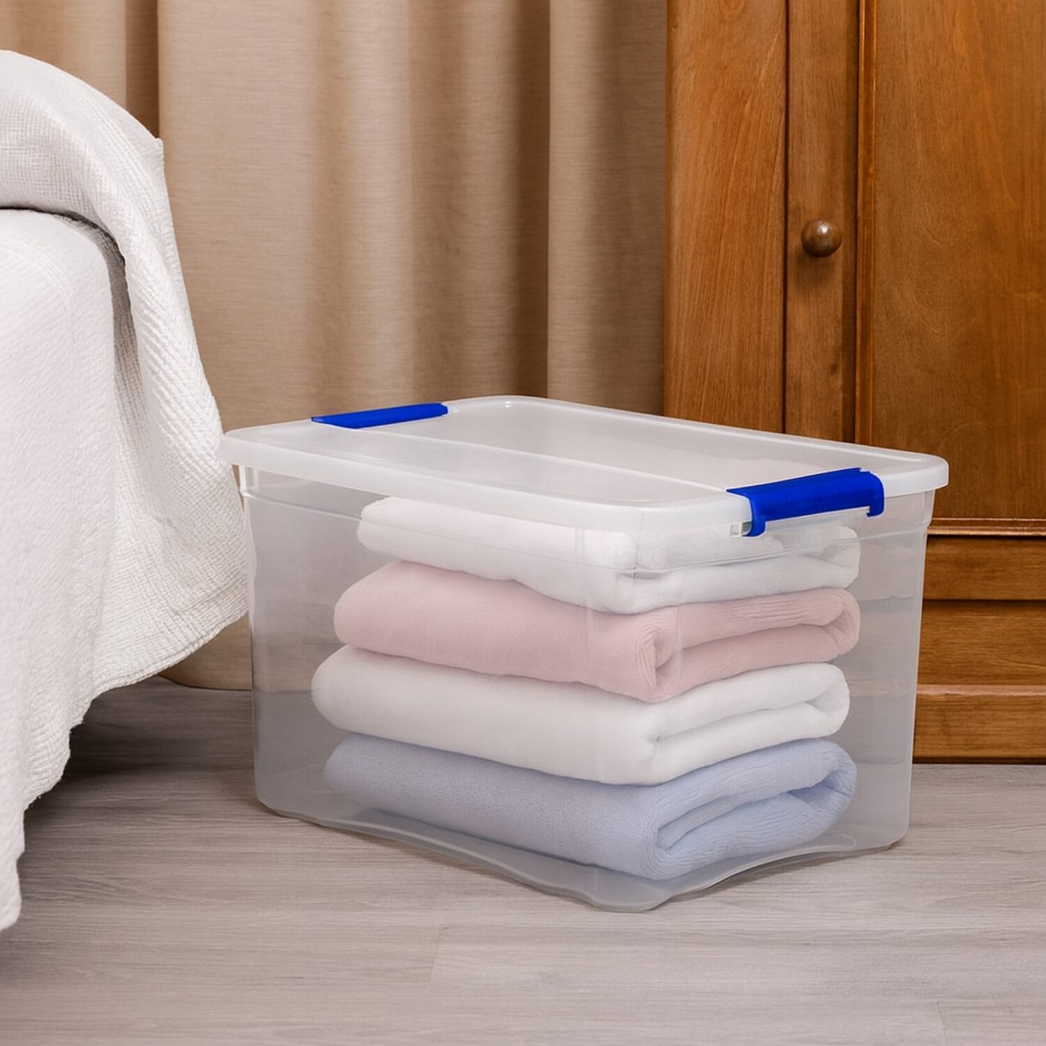 Contenitore 65 litri trasparente con plaid piegati sotto il letto in camera da letto