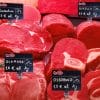 ambientata-kit-segnaprezzi-macelleria Cartellini segnaprezzi neri esposti su banco macelleria con tagli di carne fresca