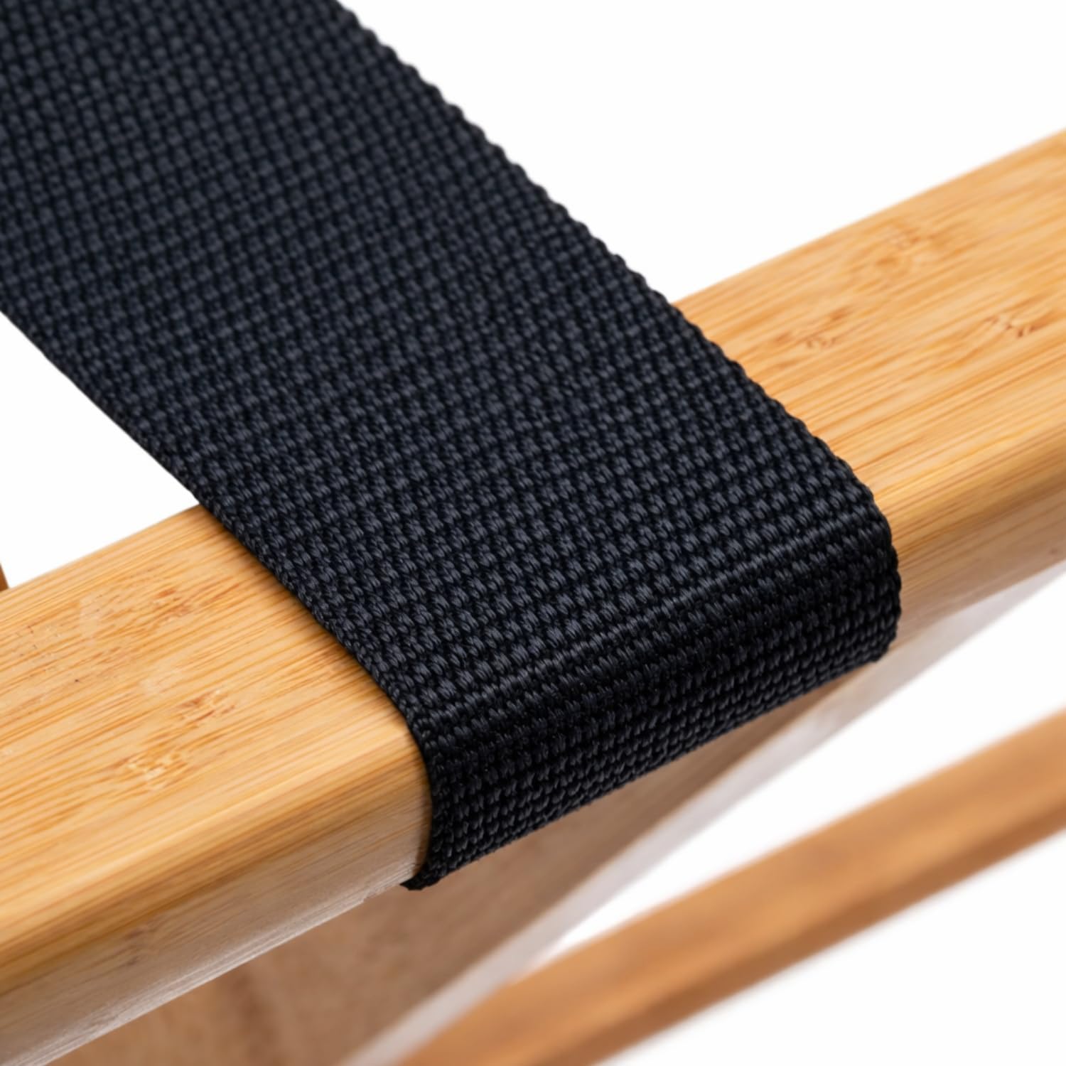 Dettaglio cinghia nera resistente su porta valigia in legno bamboo, supporto stabile per bagagli e trolley
