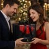 Coppia felice che scambia un cofanetto regalo con rose artificiali rosse a forma di cuore