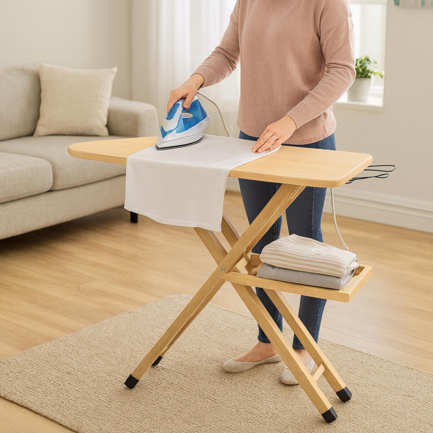 Asse da stiro in legno naturale usata in ambiente domestico, con ripiano portabiancheria e poggiaferro in metallo