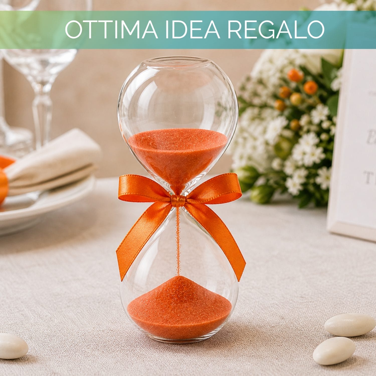 Clessidra decorativa in vetro su tavolo con elementi d’arredo, perfetta come idea regalo elegante.